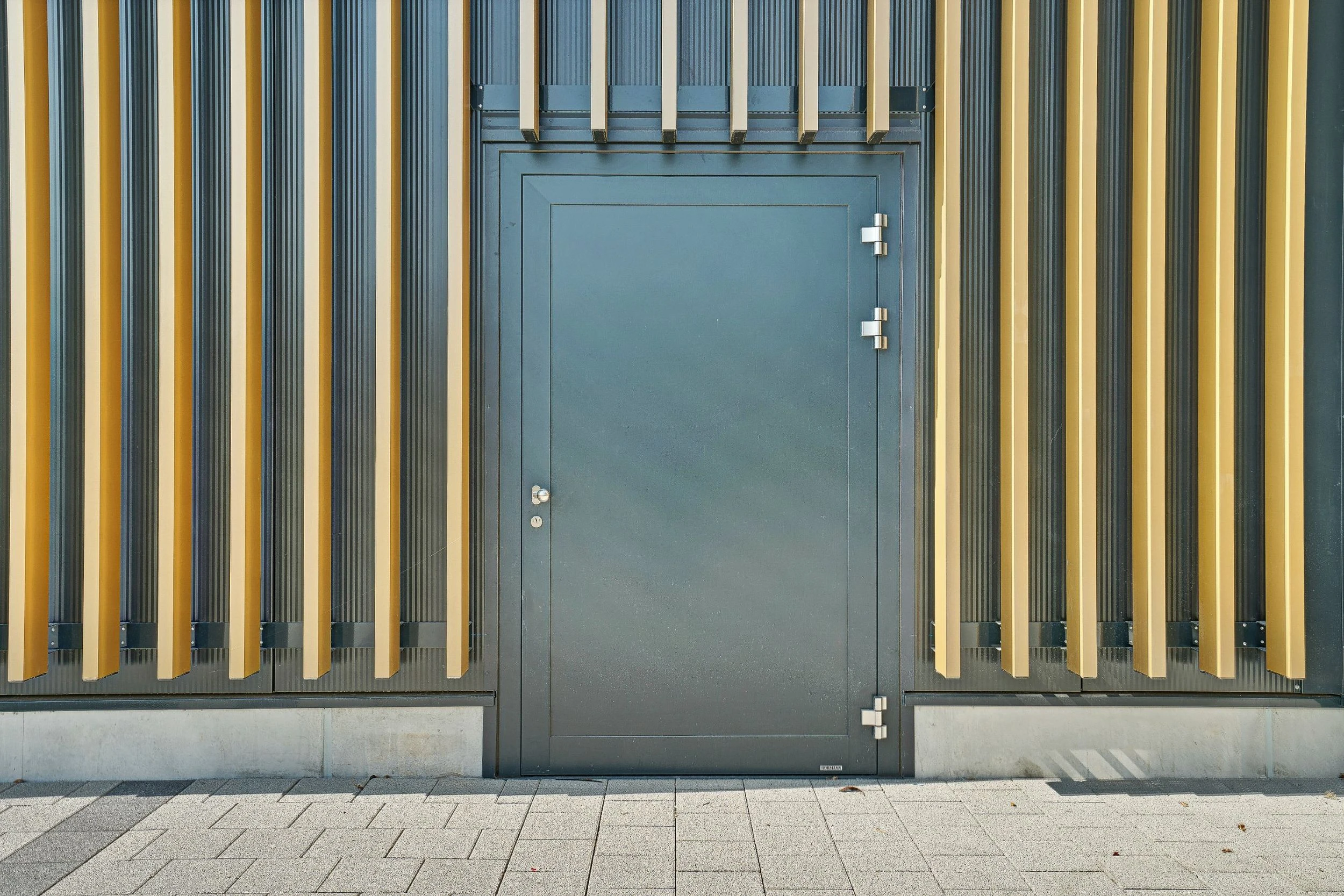 Aussentüre in Anthrazit die als Fluchttüre dient, eingebettet in schöne Holzfassade