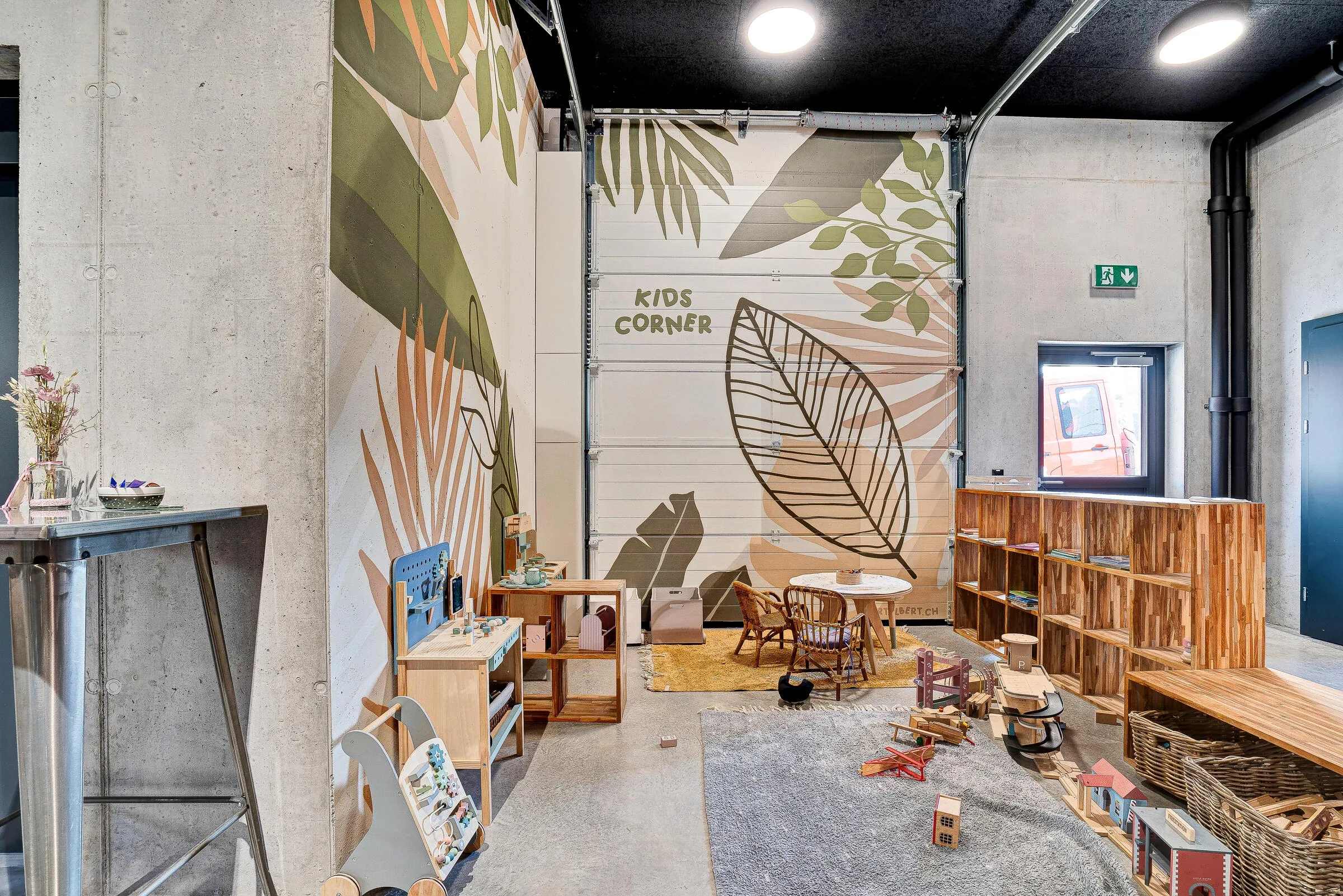 Kids Corner mit botanischer Dschungel-Wandbemalung, Holzmoebeln und Spielbereich
