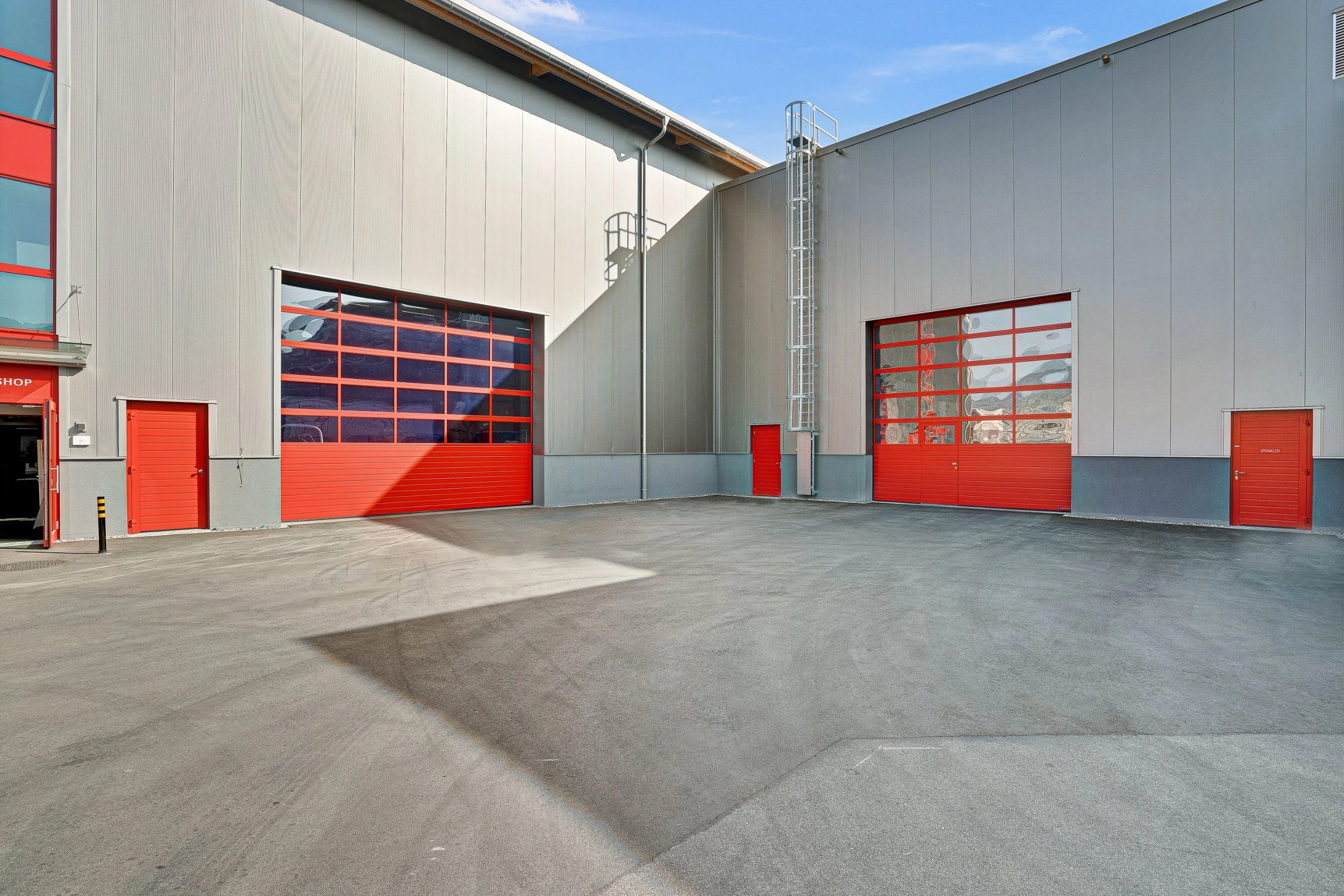 Blick auf 2 rote Industrietore mit integrierten Fenstern