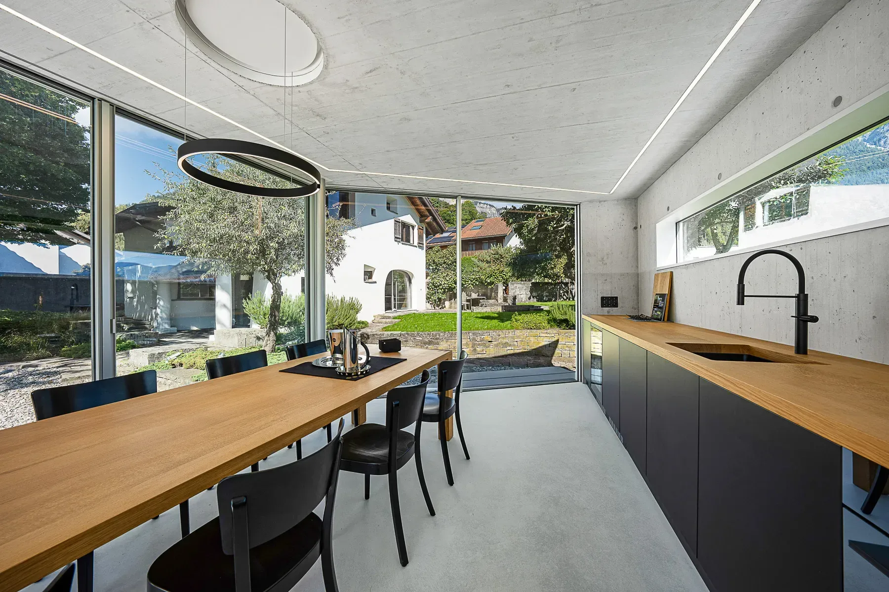 Blick aus dem Glaspavillon durch teilweise geöffnete, rahmenlose Schiebefenster Sky-Frame