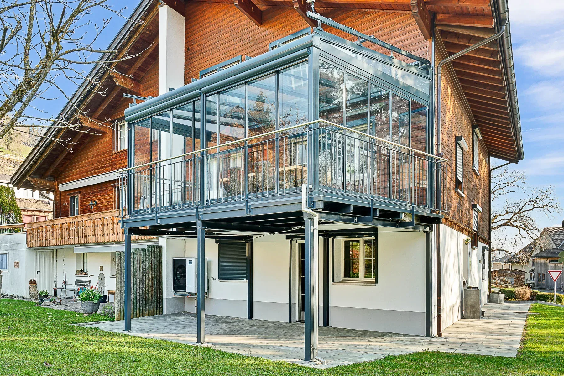 Der bestehende schmale Balkon wurde zu einer grosszügigen Terrasse inkl, Schiebe-Dreh-Schiebewand und Pultdach von Solarlux