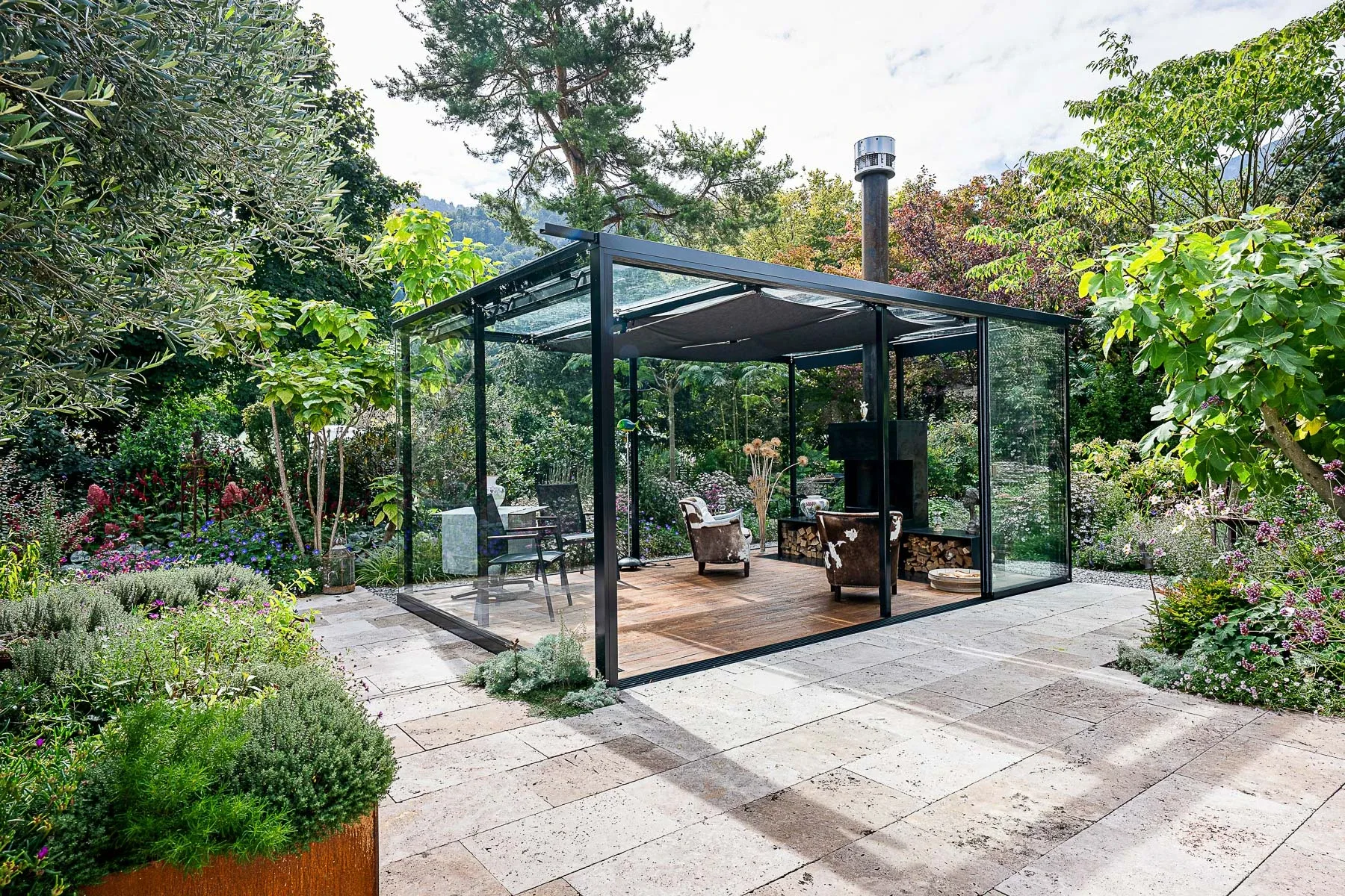 Gesamtansicht der Outdoor Cigar Lounge mit Natursteinplatten und Rauchabzug