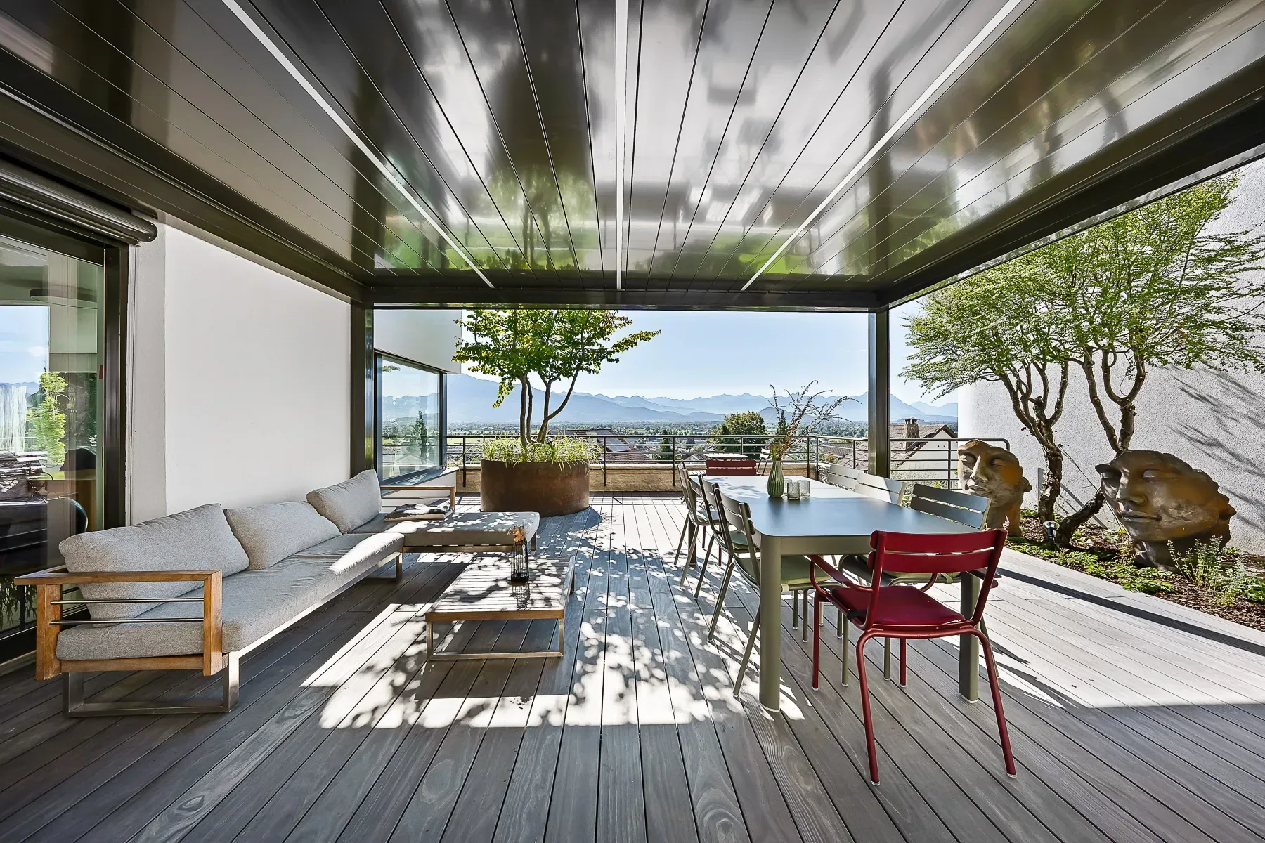 Draufsicht auf Pergola und begrünte Dachterrasse mit weitem Alpenpanorama