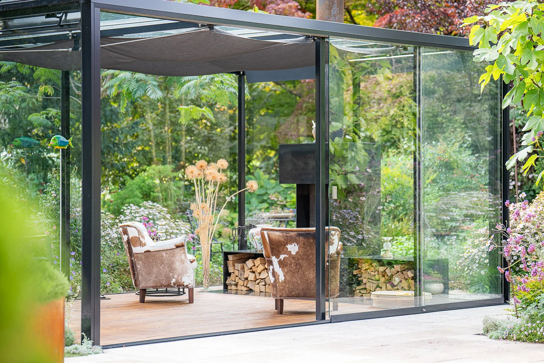 Gesamtansicht der Glaslounge mit Buchsbaumhecke im Vordergrund