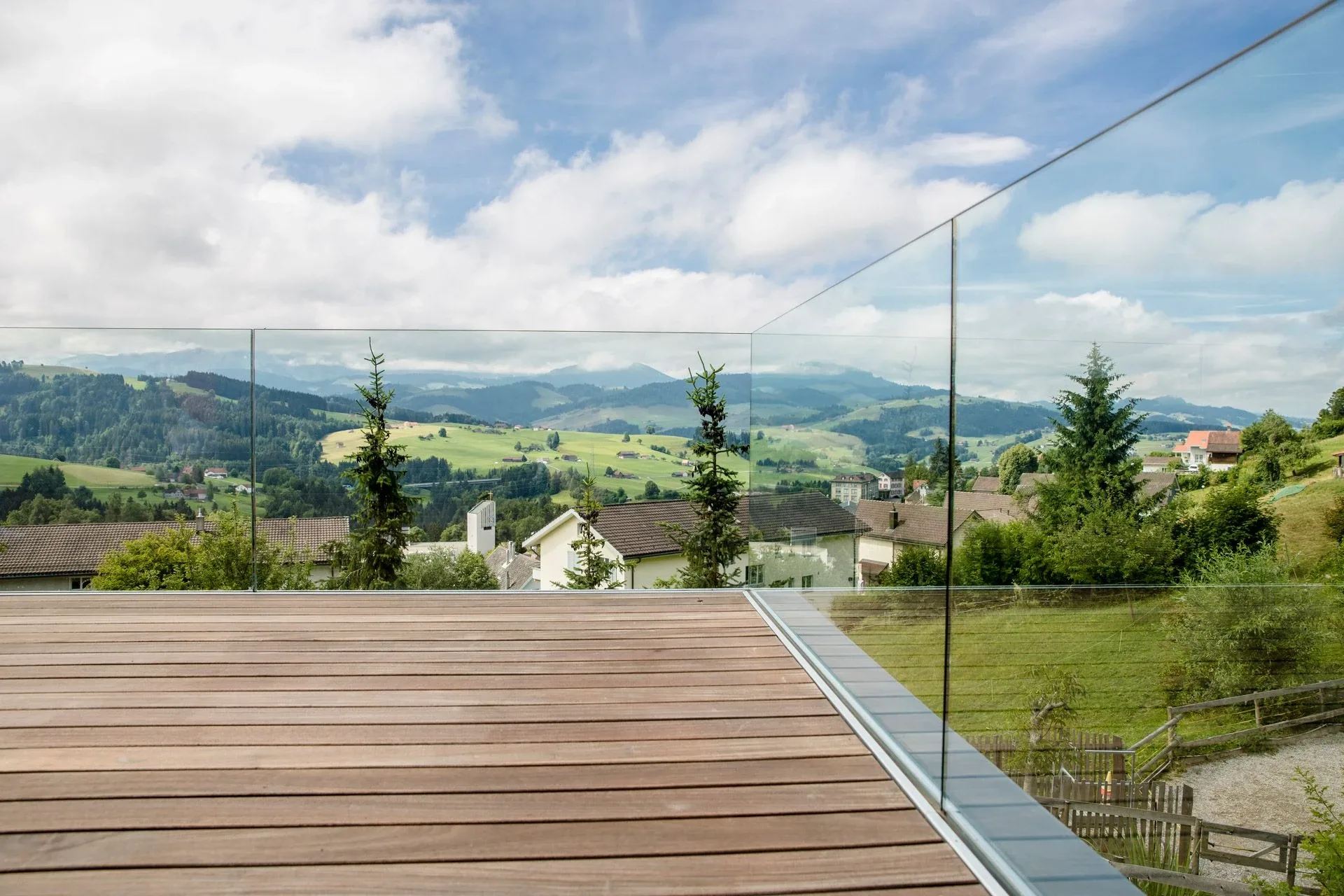 Ganzglasgeländer rund um eine Terrasse mit Holzboden, mit Blick auf den Alpstein