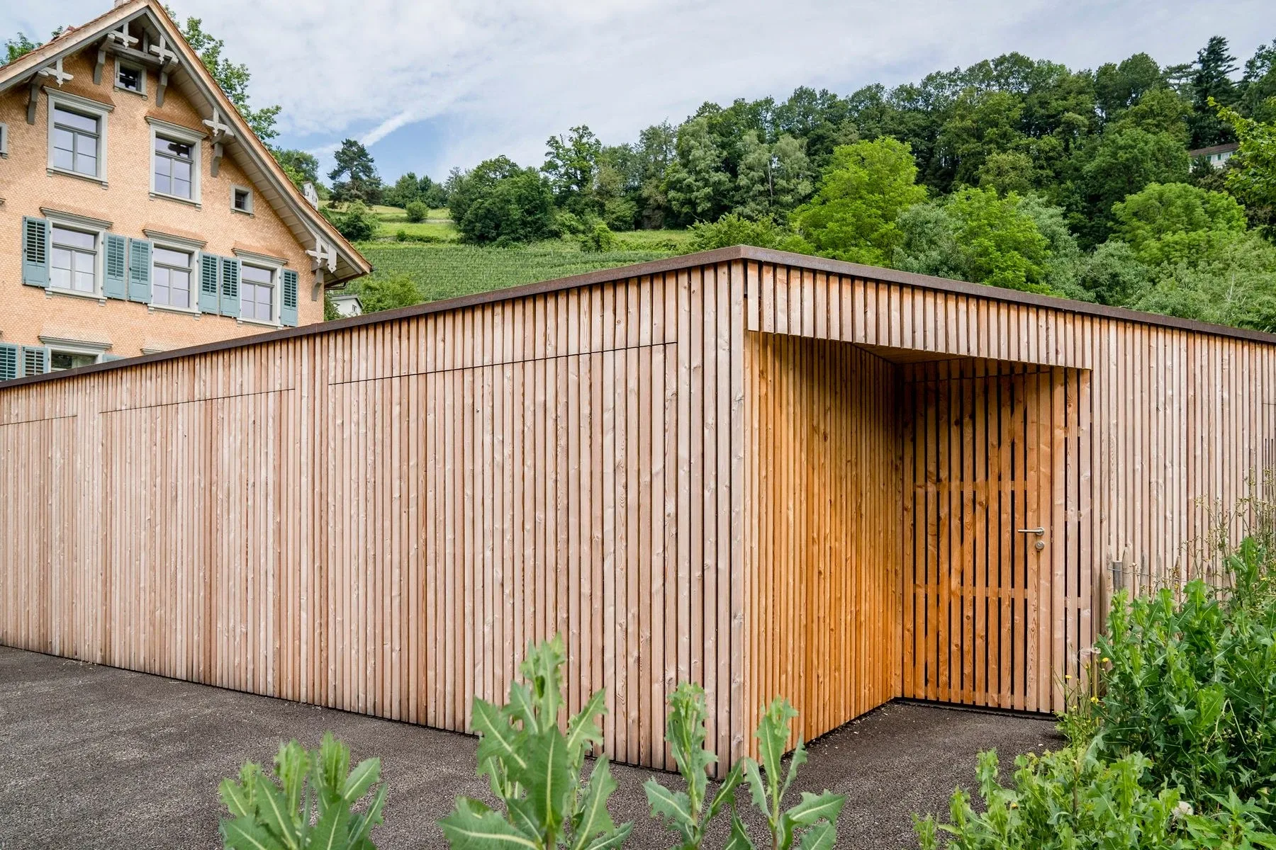 Garagen- und Veloport mit Holzbeplankten Garagentor, alt und neu kombiniert.