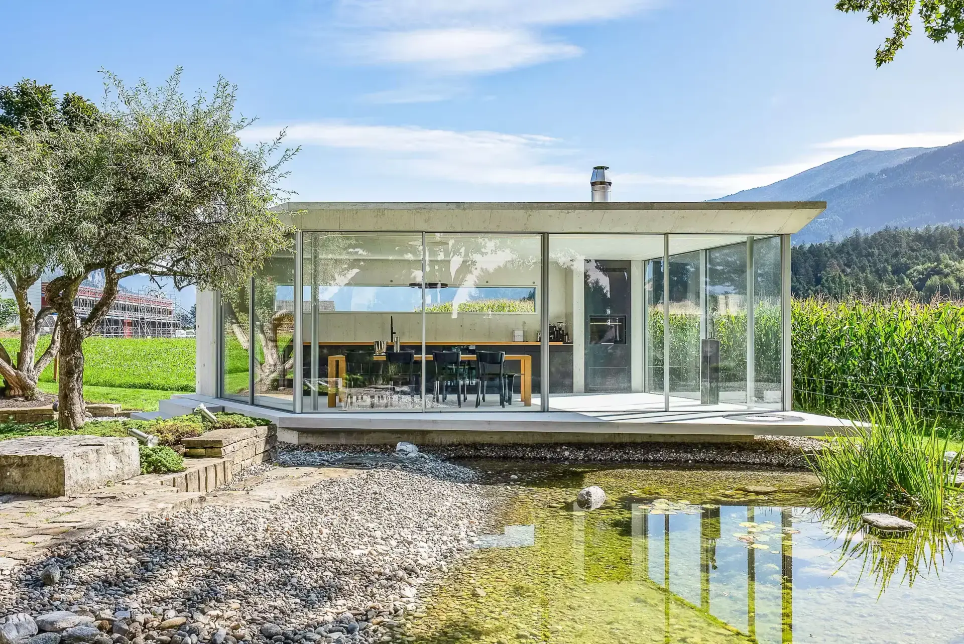 Glashaus mit rahmenlosen Schiebefenster der Marke Sky-Frame am Biotop im Grünen