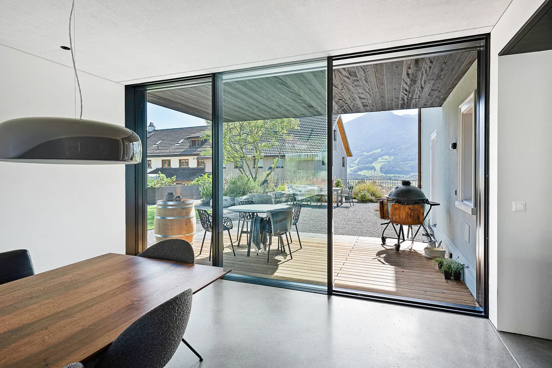 Innenansicht Esszimmer mit Sky-Frame-Verglasung und Blick auf Terrasse und Berge