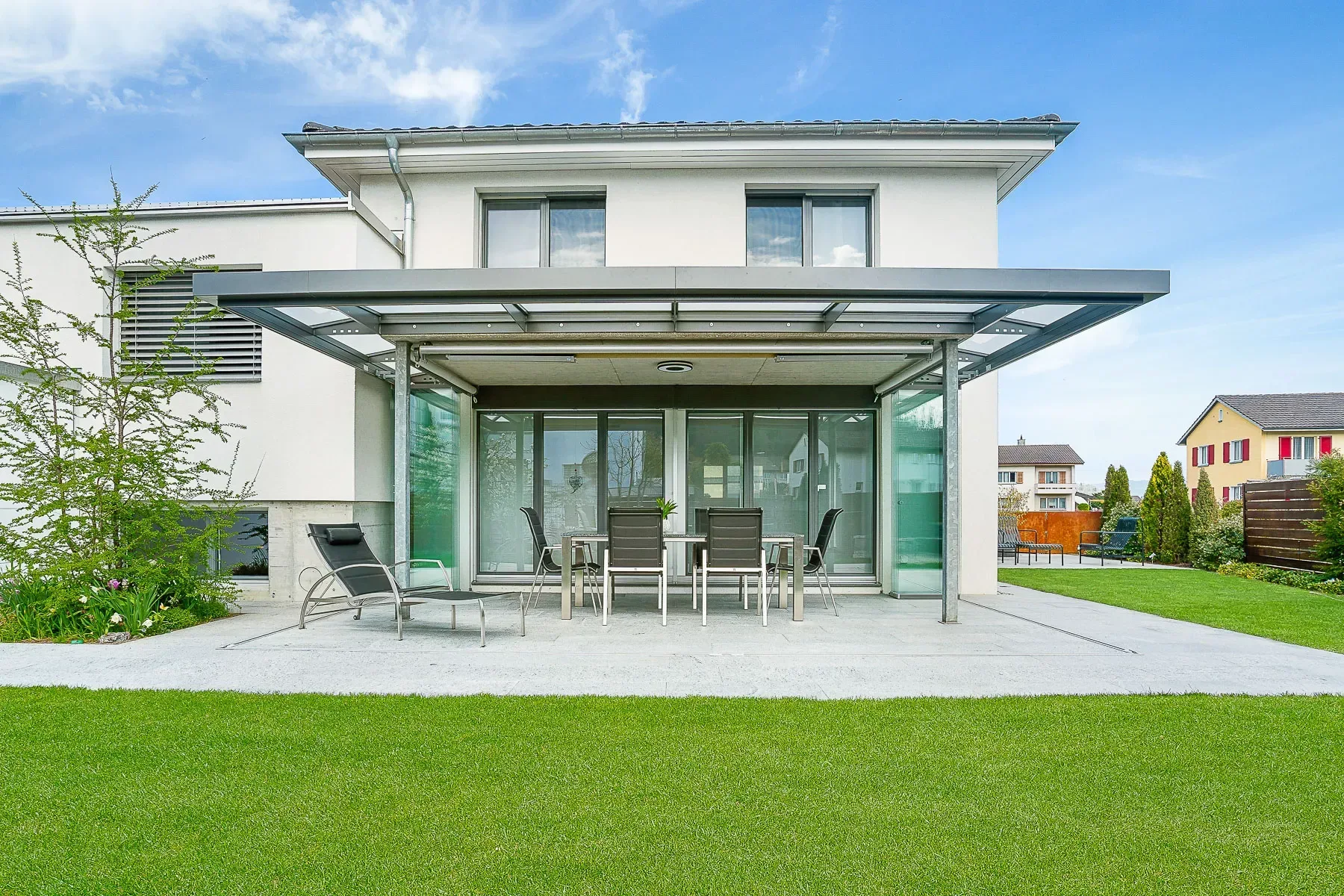 Schiebe-Dreh Sitzplatzverglasung SL25 von Solarlux, ganz geöffnet umgeben von Rasen und Bäumen, Nachher