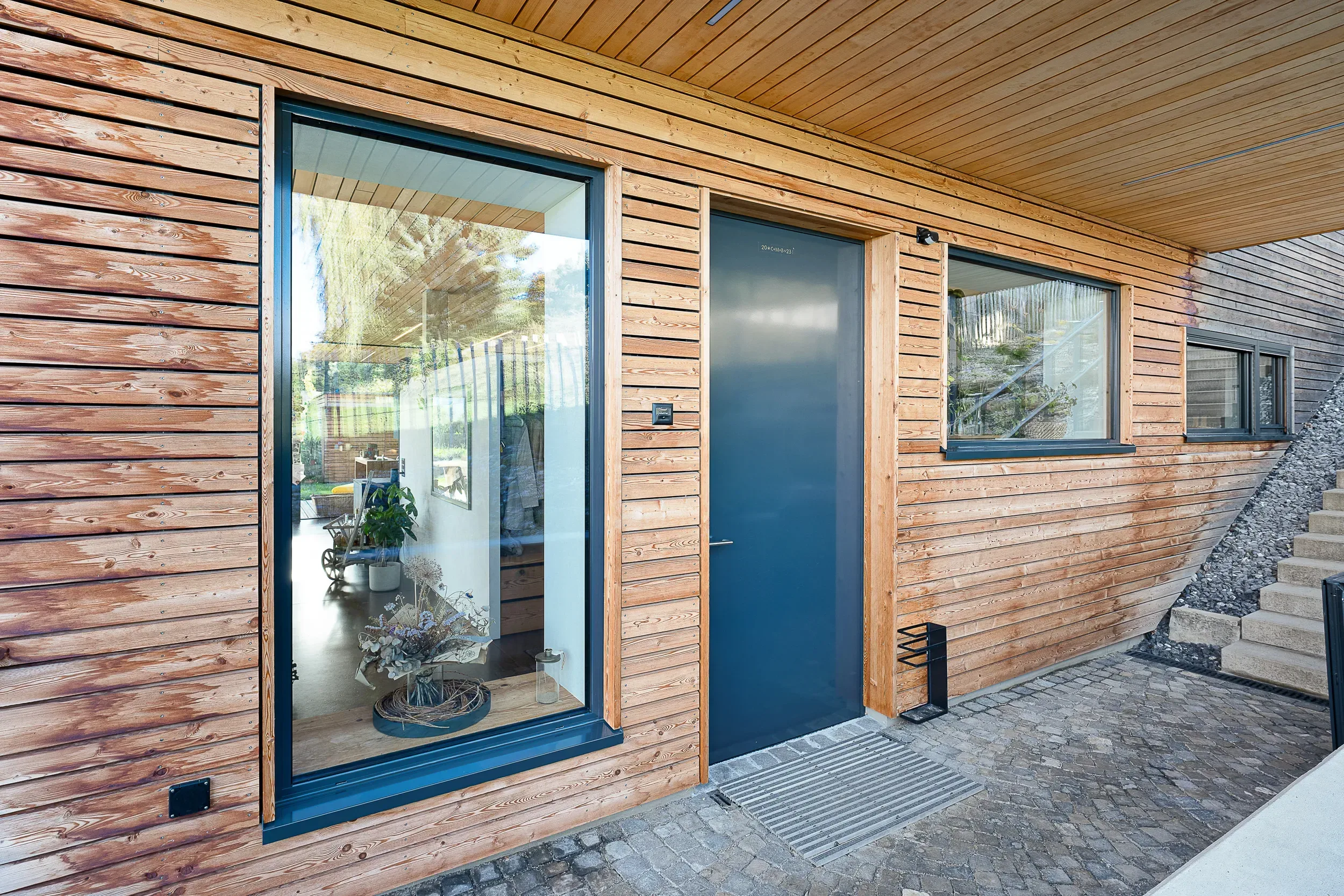 Schüco-Haustüre aus Aluminium in Blaugrau in Holzfassade — Neubau Marbach