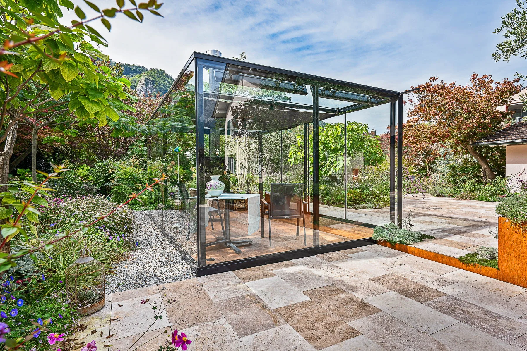 Lounge von der Terrasse mit Corten-Pflanztrog, Olivenbaum und Bodenspots