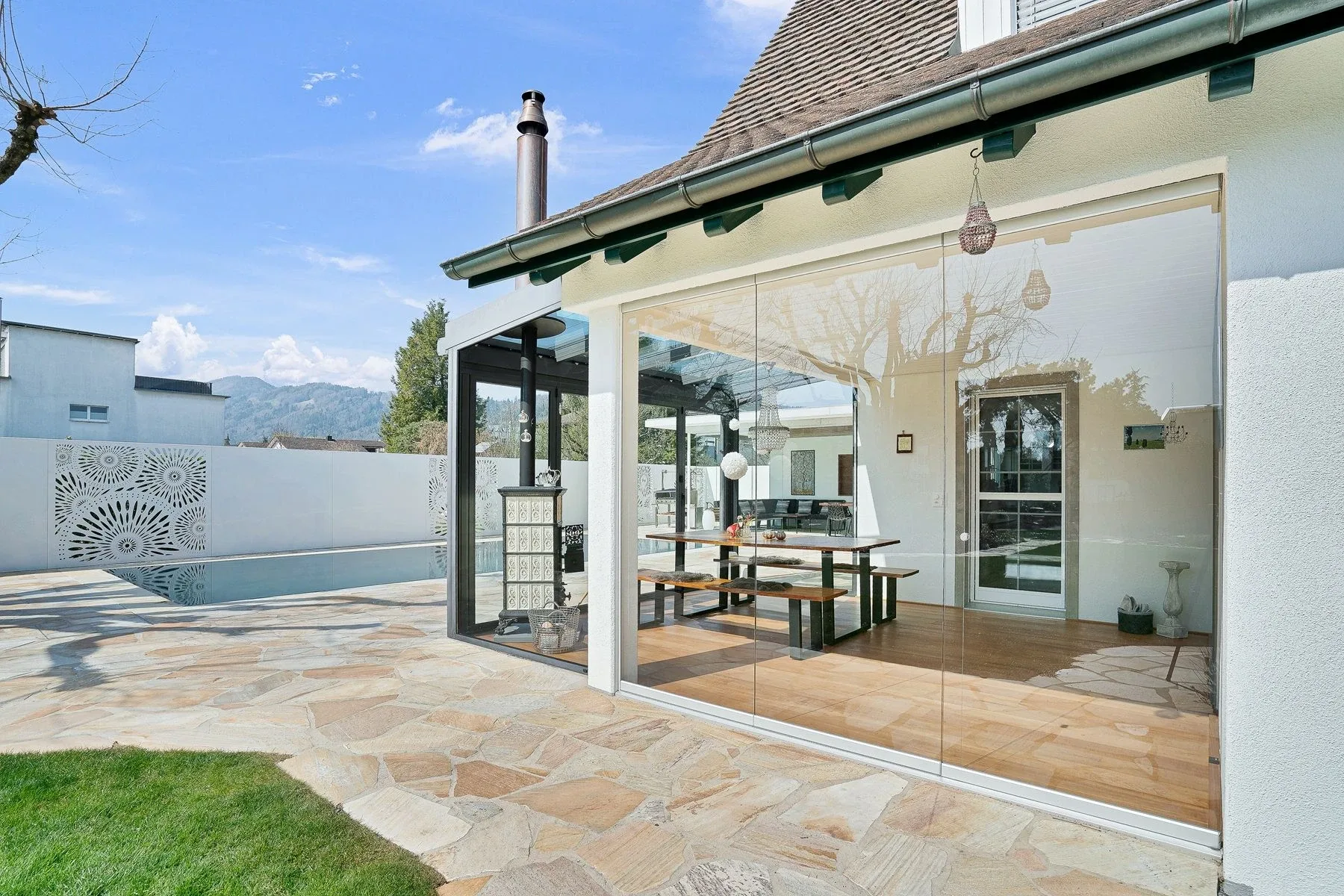 seitlicher Blick an die Dreh-Schiebe Verglasung welche die Natur ins Hause bringt