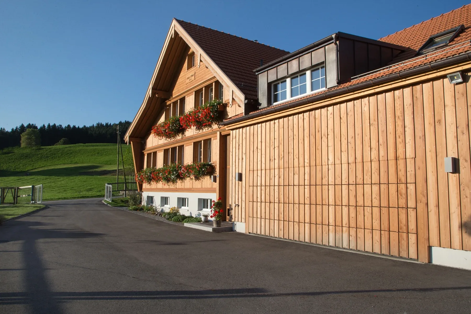 Sektionaltor mit Holzbeplankung bei einem renovierten Bauernhaus.