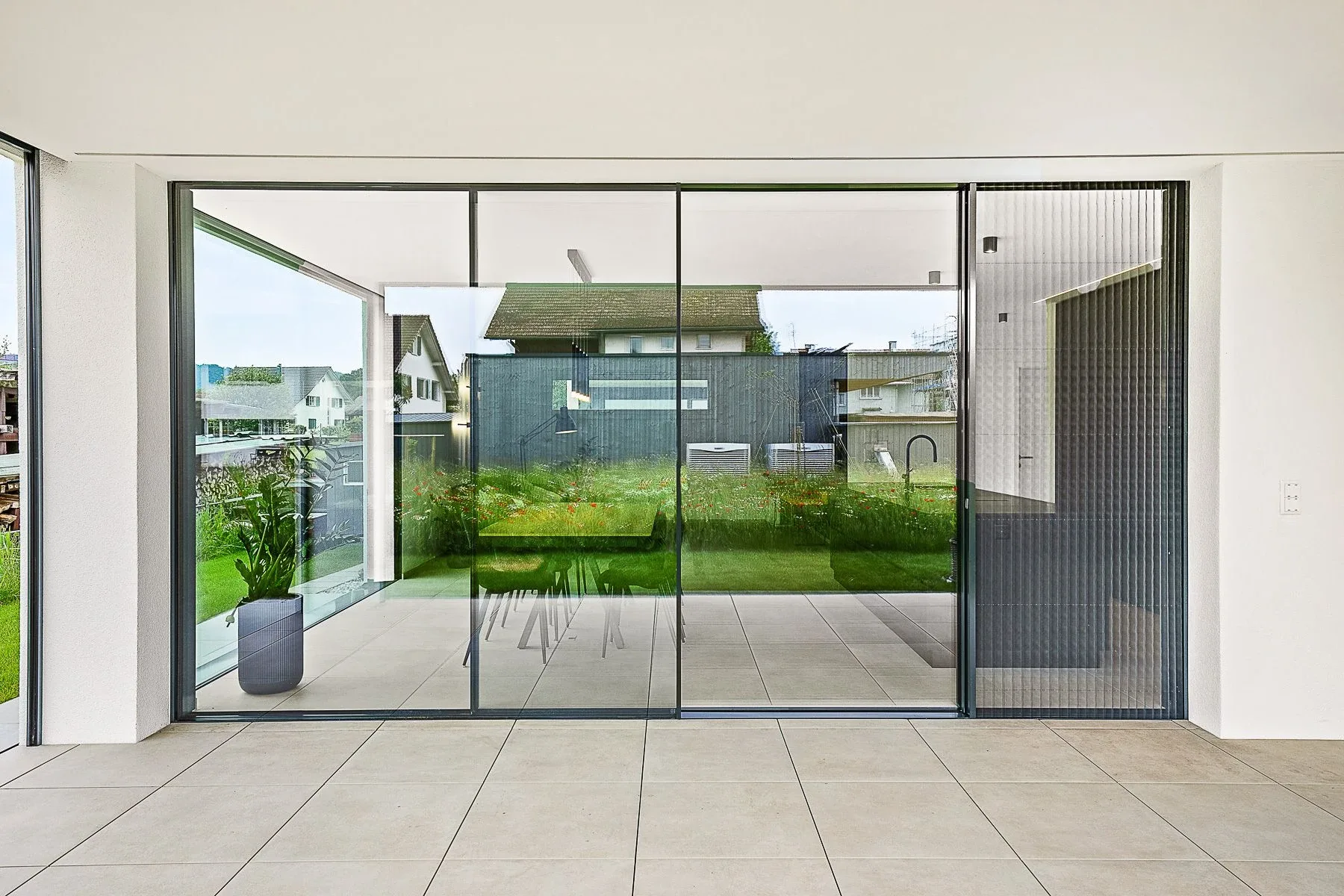 Sicht auf die rahmenlose Sky-Frame Verglasung seitlich geöffnet, als Schutz gegen Insekte ist das integrierte Insektengitter (Fly) bündig geschlossen