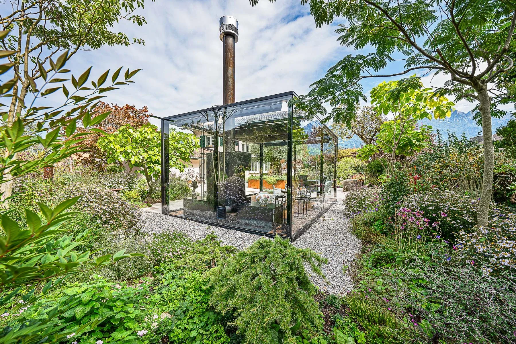 Gesamtansicht der Outdoor Cigar Lounge mit Natursteinplatten-Terrasse und Corten-Pflanztrog