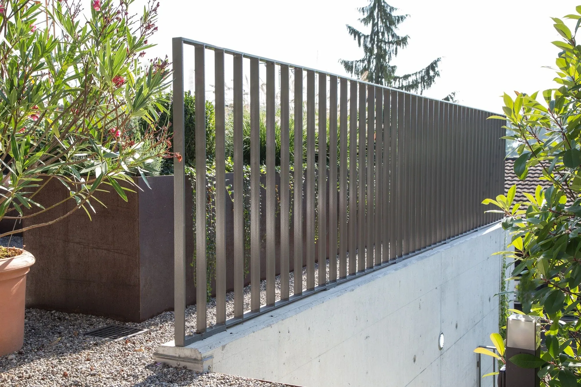 Staketengeländer als Absturzsicherung am Rande einer Gartenterrasse 
